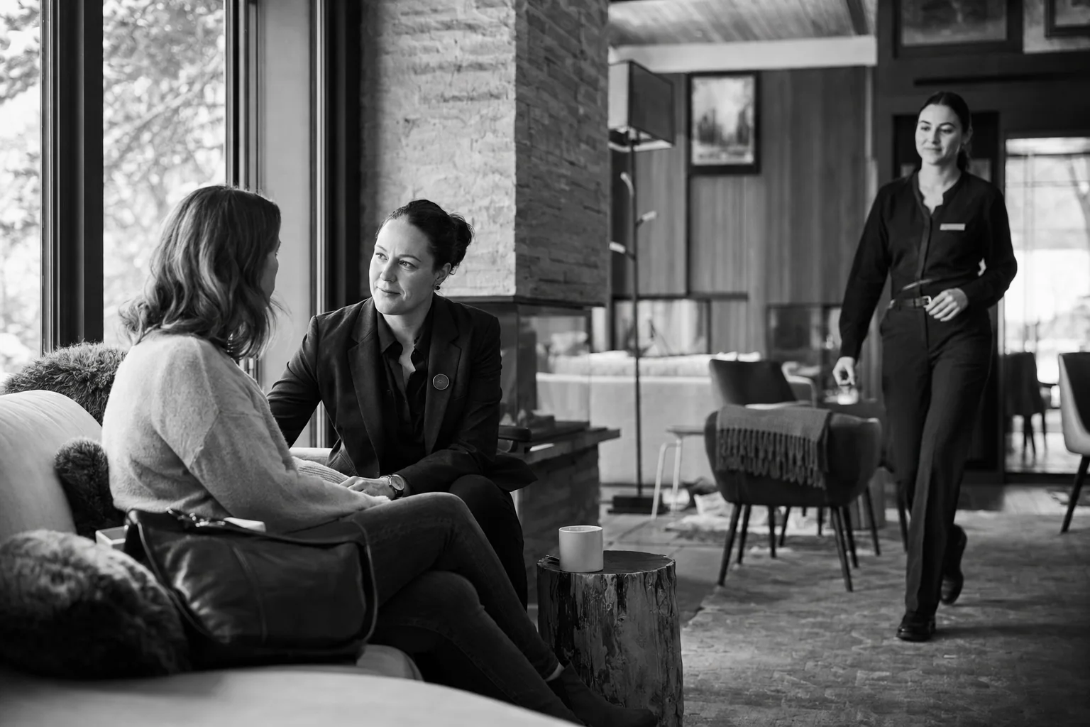 A hotel colleague reassuring a guest while a teammate approaches to take ownership